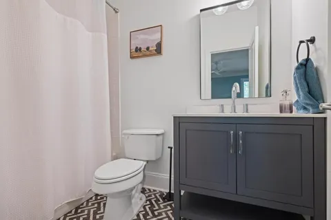 a bathroom with a toilet sink and mirror