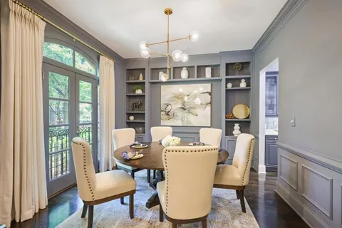 a dining room with furniture a chandelier and wooden floor