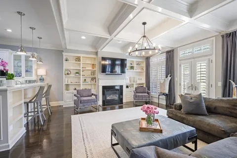 a living room with fireplace furniture and a chandelier