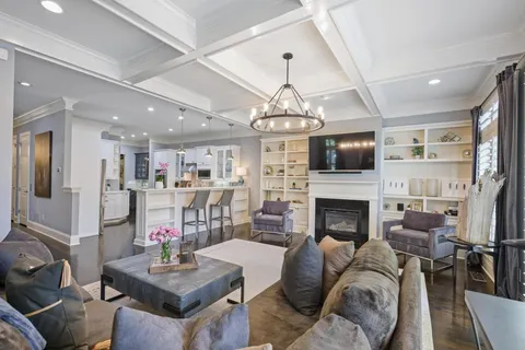 a living room with fireplace furniture and a chandelier