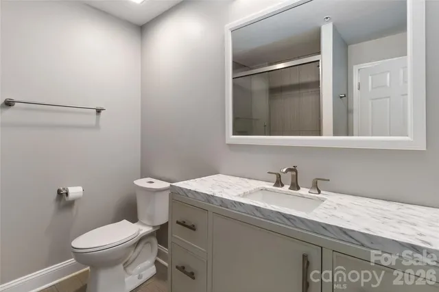 a bathroom with a granite countertop toilet sink and mirror