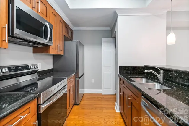 a kitchen with stainless steel appliances granite countertop a sink and a stove