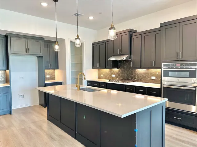 a kitchen with a refrigerator sink and wooden cabinets