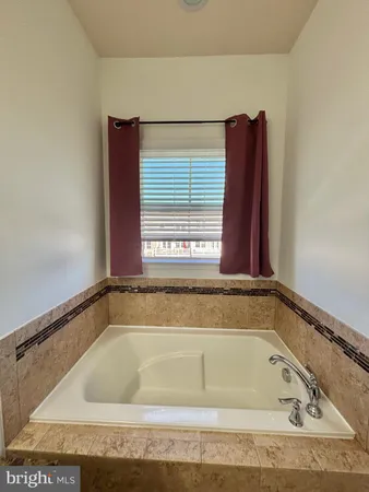 a bath tub sitting in a bathroom next to a window
