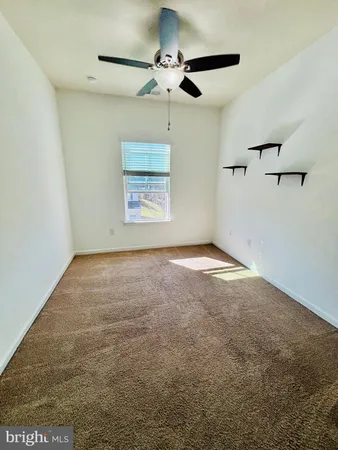 a view of room with a ceiling fan and window