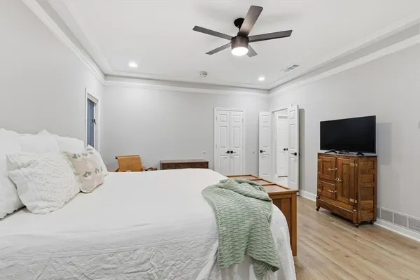 a spacious bedroom with a bed and a flat screen tv