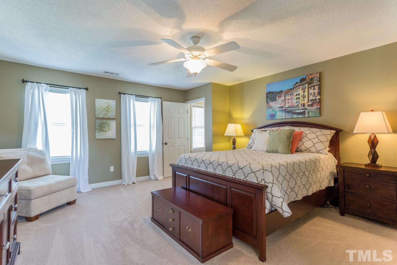 4316 Birmingham Way Raleigh, NC 27604 - Photo 14 of 25 a bedroom with a large bed and a chandelier