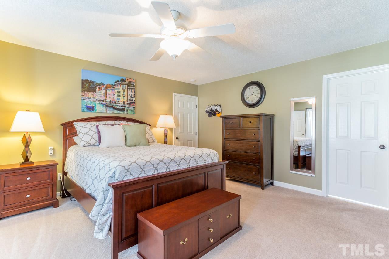 4316 Birmingham Way Raleigh, NC 27604 - Photo 15 of 25 a bedroom with a bed and a chandelier