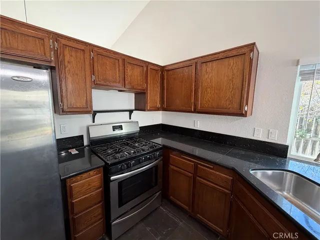 a kitchen with stainless steel appliances granite countertop a stove a sink and a microwave