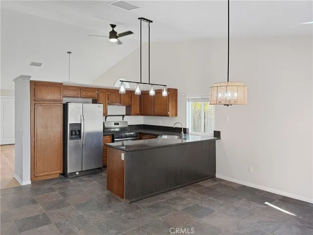 a view of kitchen with stainless steel appliances granite countertop cabinets and refrigerator