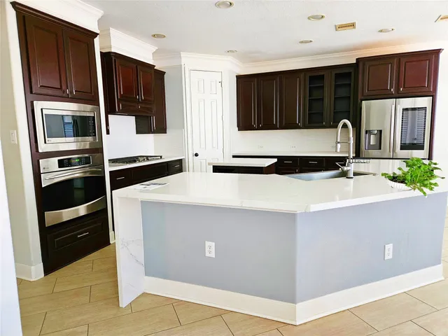 a kitchen with kitchen island granite countertop a refrigerator stove and cabinets