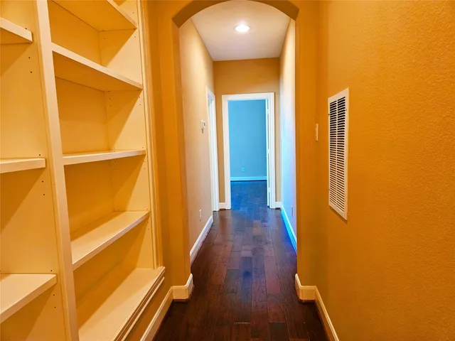 a view of a hallway with wooden floor