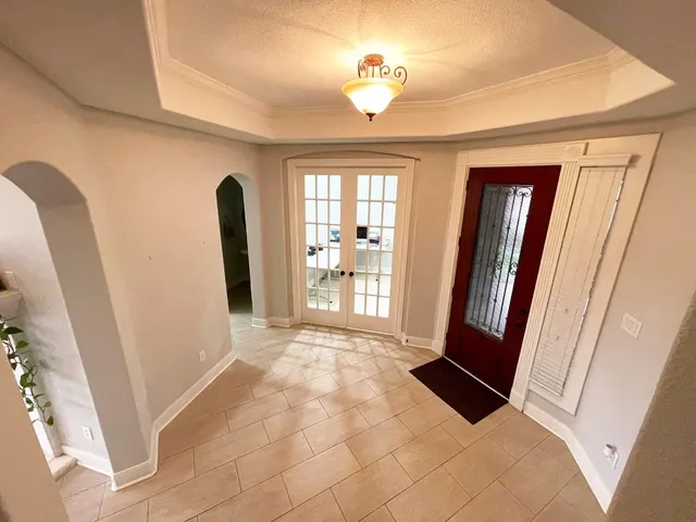 a view of a hallway with windows and chandelier