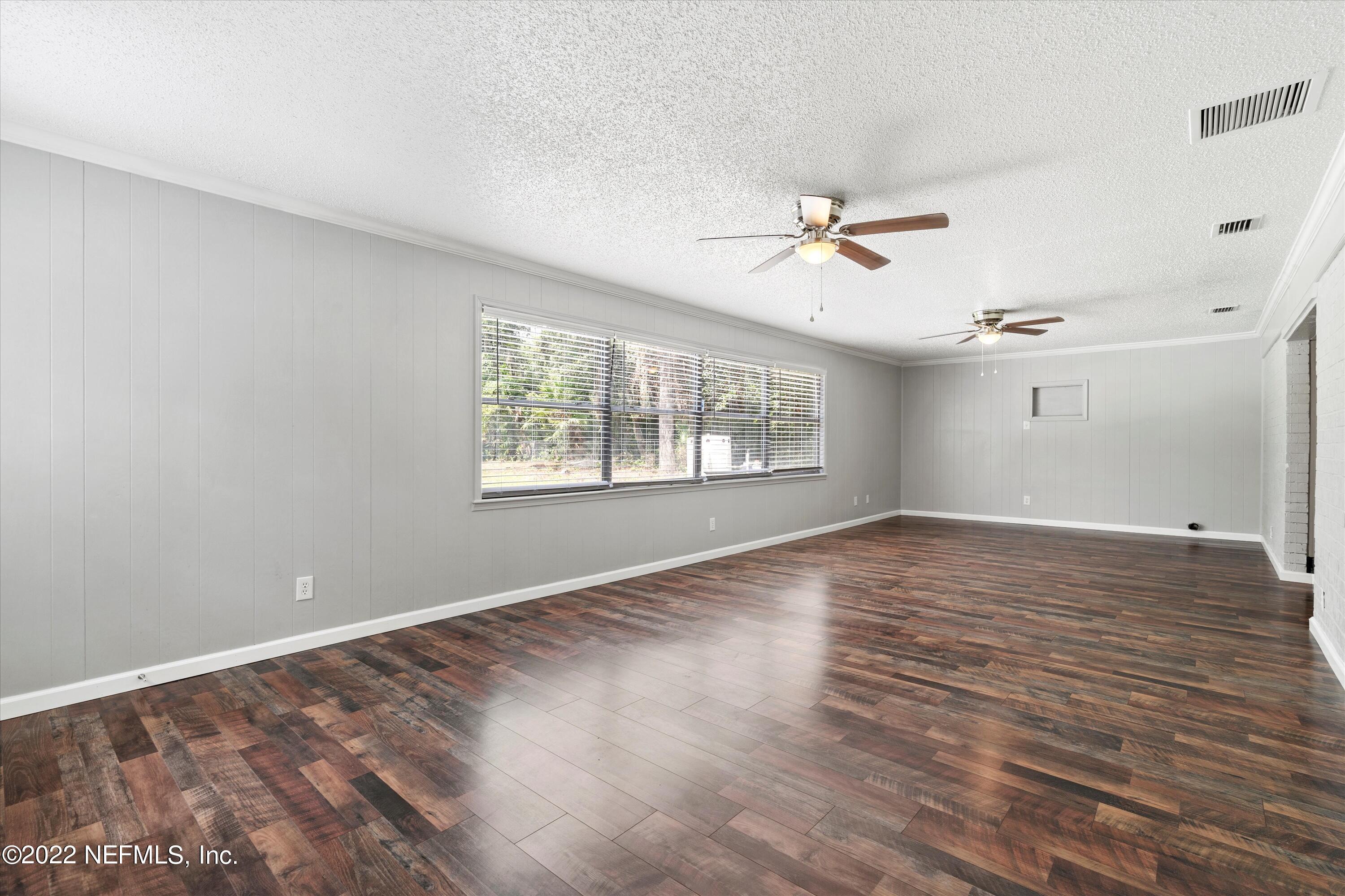 5092 Harvey Grant Road Fleming Island, FL 32003 - Photo 20 of 38 an empty room with wooden floor ceiling fan and windows