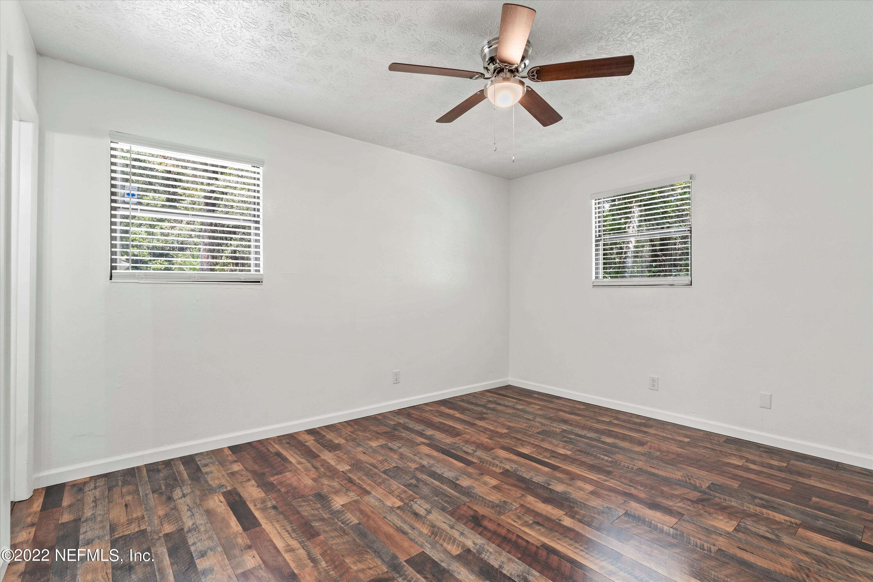 5092 Harvey Grant Road Fleming Island, FL 32003 - Photo 21 of 38 a view of empty room with wooden floor and fan