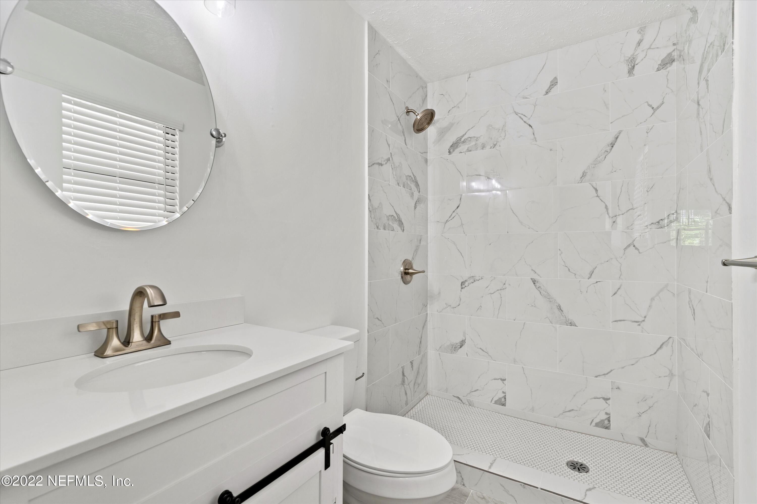 5092 Harvey Grant Road Fleming Island, FL 32003 - Photo 23 of 38 a bathroom with a sink a toilet and shower