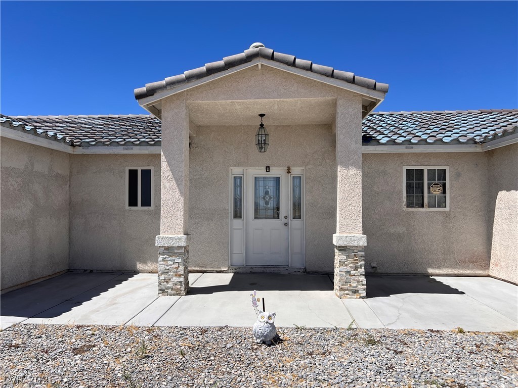 200 East Gamebird Road Pahrump, NV 89048 - Photo 2 of 23 A welcoming entry with decorative columns and a tiled roof enhances this home's curb appeal.