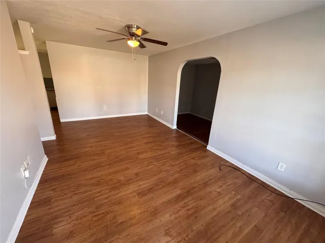 a view of a livingroom with wooden floor and a ceiling fan