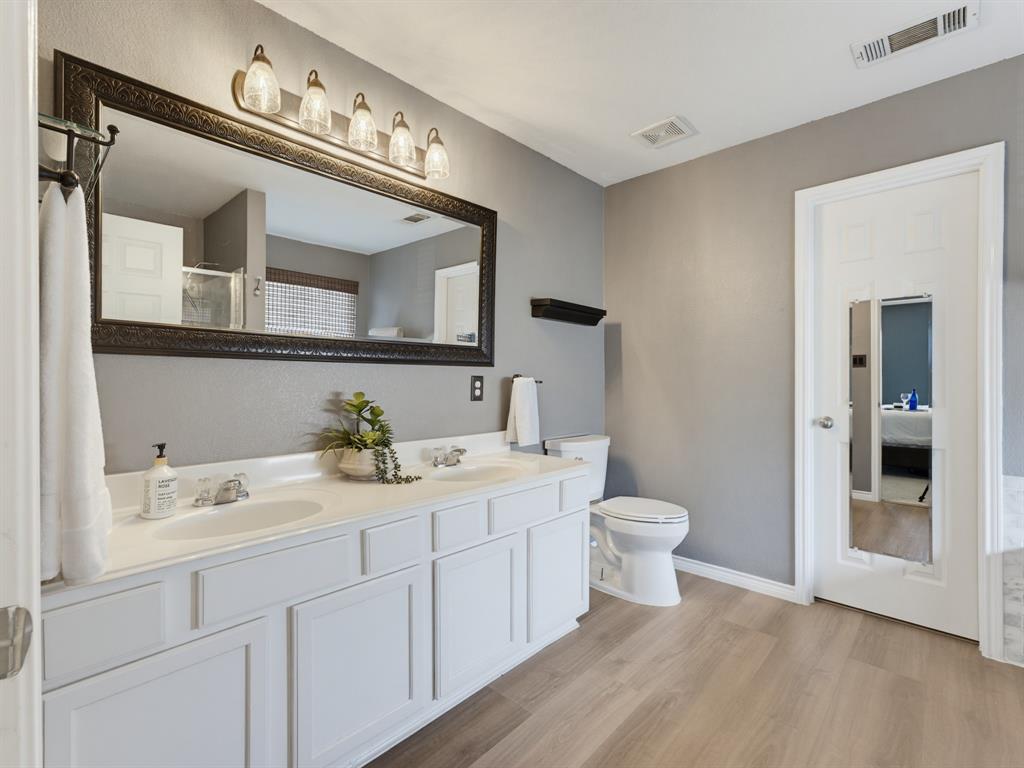 13268 Fencerow Road Fort Worth, TX 76244 - Photo 11 of 25 Double vanity with white cabinetry, dual sinks, and a large framed mirror