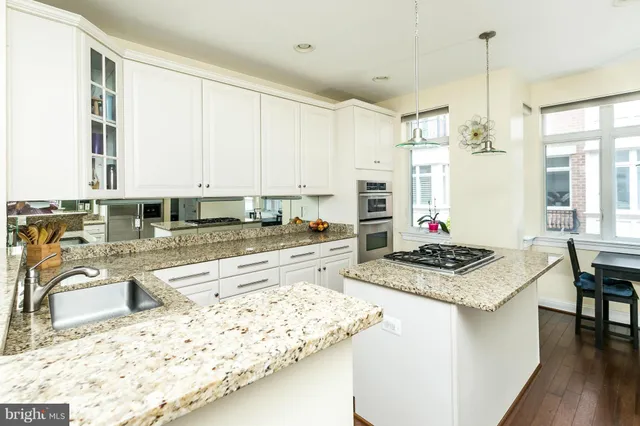a kitchen with stainless steel appliances granite countertop a stove a sink and a refrigerator