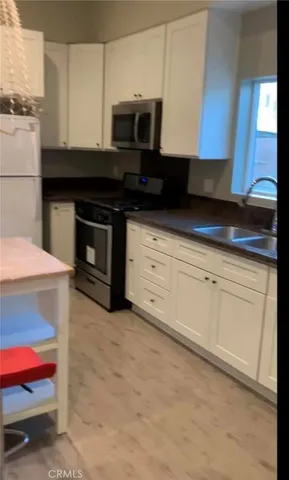 a kitchen with white cabinets and black appliances