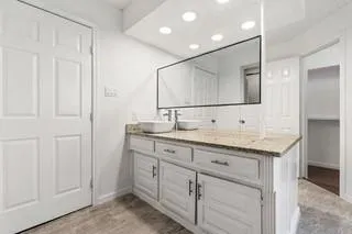 a bathroom with a granite countertop sink and a mirror