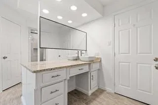 a bathroom with a granite countertop sink and a mirror