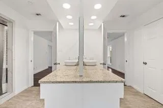 a bathroom with a granite countertop sink and a mirror