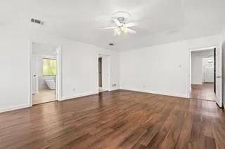 an empty room with wooden floor and mirror