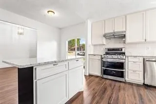 a kitchen with white cabinets and appliances