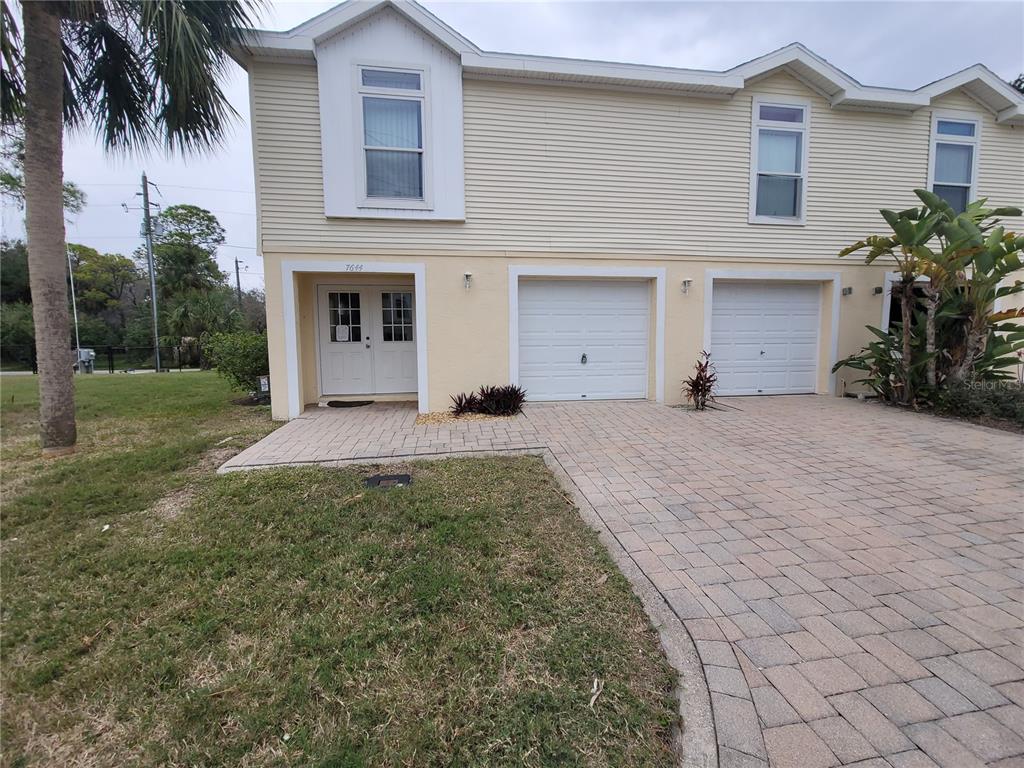 7644 Sailwinds Pass Port Richey, FL 34668 - Photo 1 of 22 a view of a house with a yard and a garage