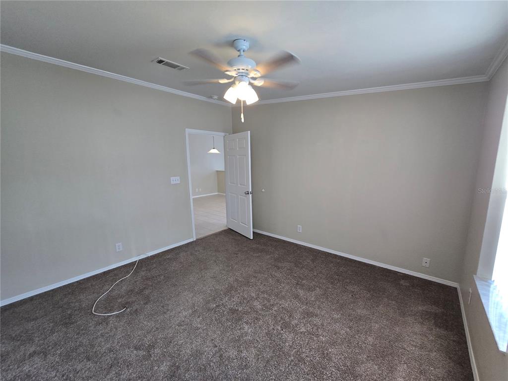 7644 Sailwinds Pass Port Richey, FL 34668 - Photo 13 of 22 an empty room with a chandelier fan and closet