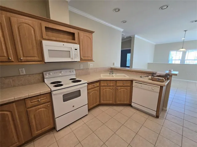 a white kitchen with stainless steel appliances granite countertop a stove and a sink