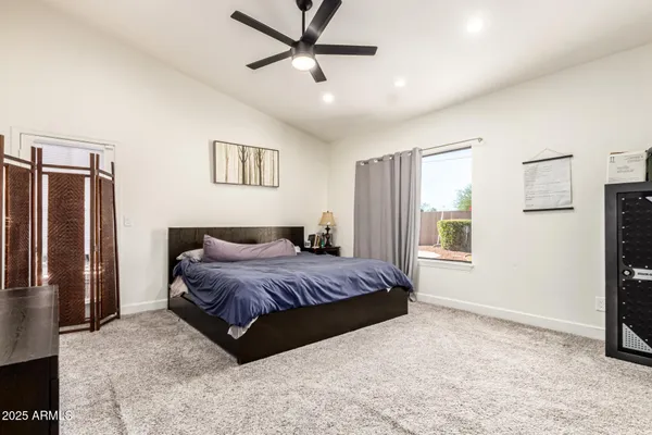 a spacious bedroom with a bed and a refrigerator