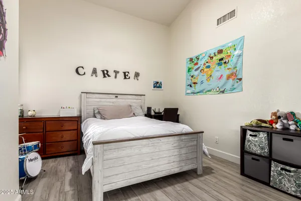 a bedroom with a bed and wooden floor