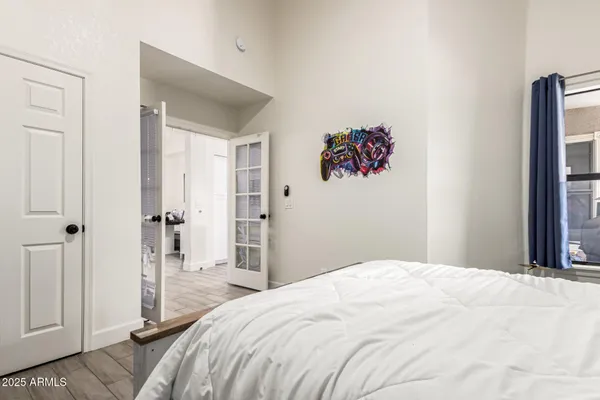 a bedroom with a large bed and a chandelier
