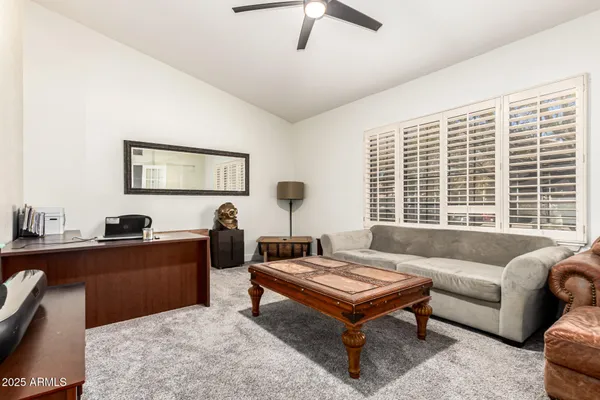 a living room with furniture a flat screen tv and a window