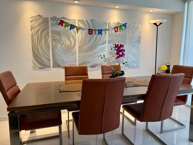a dining room with furniture and large windows