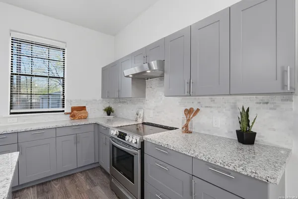 a kitchen with stainless steel appliances granite countertop a sink stove and cabinets