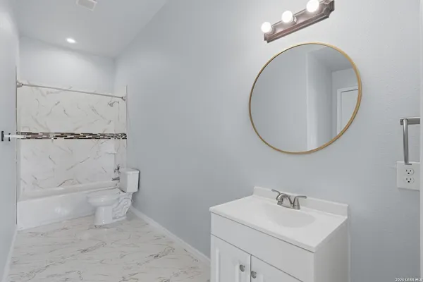 a bathroom with a sink a toilet and a mirror