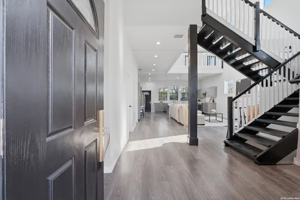 a view of a hallway with wooden floor and staircase