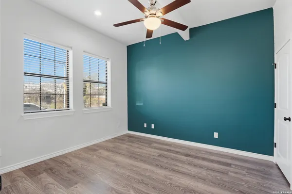 an empty room with windows and fan