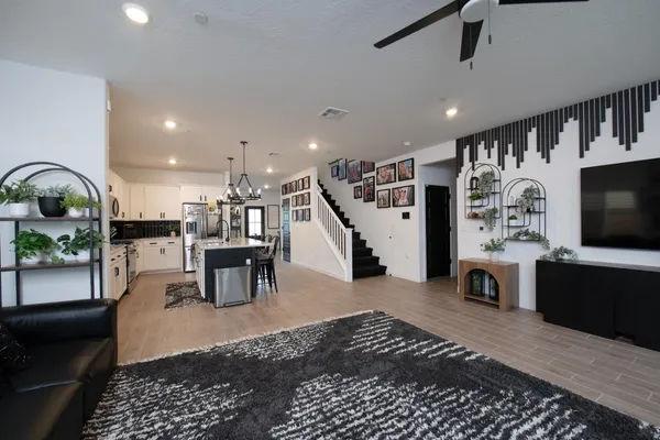 a living room with furniture a flat screen tv and a table