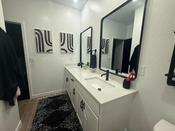 a bathroom with a double vanity sink and a mirror