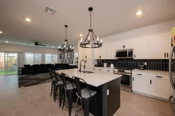 a kitchen with kitchen island granite countertop a sink a counter and chairs