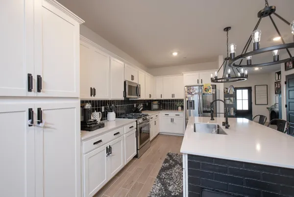 a kitchen with a sink stainless steel appliances and white cabinets