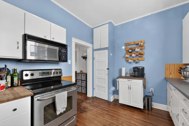 a kitchen with stainless steel appliances granite countertop a stove top oven a sink dishwasher and cabinets with wooden floor