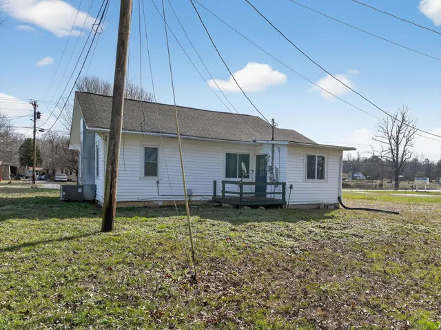 a view of a house with backyard and sitting area