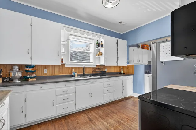 a kitchen with granite countertop white cabinets and white appliances