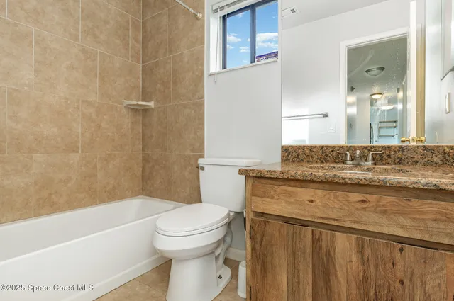 a bathroom with a granite countertop toilet a sink and bathtub